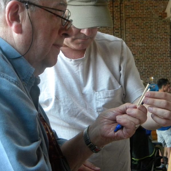 Close up of two men examining an artificial fly.